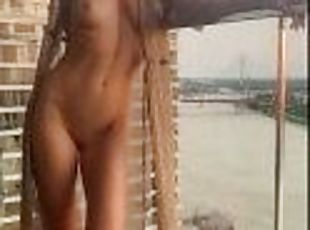 Naked woman on the balcony of a skyscraper. Nude in Public. Exhibitionist wife.