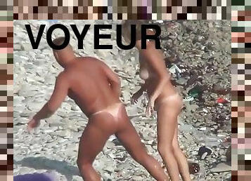 Voyeur. A guy with a tanned ass fucks a woman on a public beach