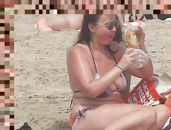 Busty mature lady has a lunch on the beach