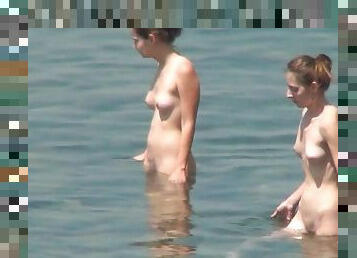 Sexy nudists are walking in the sea