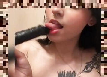 Hot brunette gives a blowjob with a big black dildo