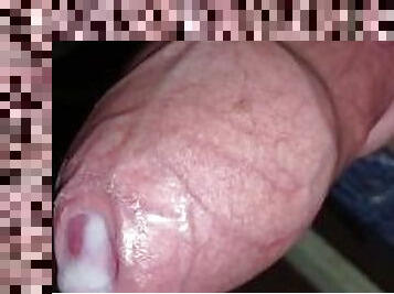 The young male squeezes the red-pink testicles. Large penis head, delicate smooth skin. Dick cums