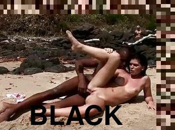 Hot wild brunette rides a big black cock on the beach