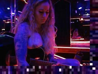 Playing guitar and singing a cover topless in club