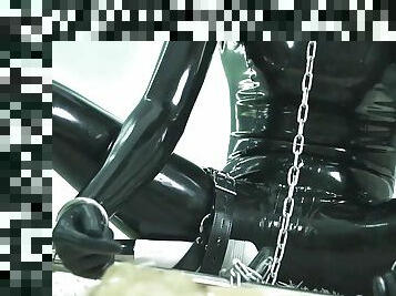 Fejira com Orgasm in a latex suit locked on a steel pipe