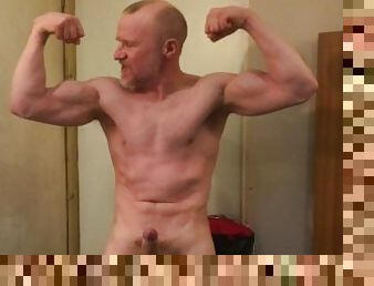 Muscular Daddy bodybuilder flexes big biceps wearing a vest then strips, jerks off and cums.