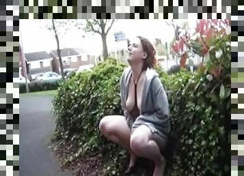 Redhead pees in the bushes in public