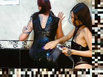 Latex fetish in the bathroom. Two beauties wash a rubber dress in the shower