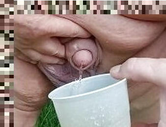 Fat Man pissing in cup outside naked with penis fart