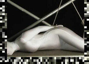 Babe wrapped in white zentai suit enjoys to be bondaged to a metal pole