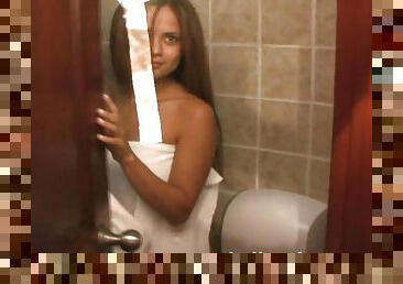 Tanned beauty is posing naked in the bathroom