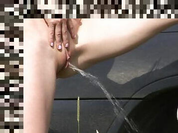 Skinny redhead pees in the grass