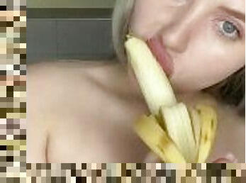 Blonde licks a banana with her lips